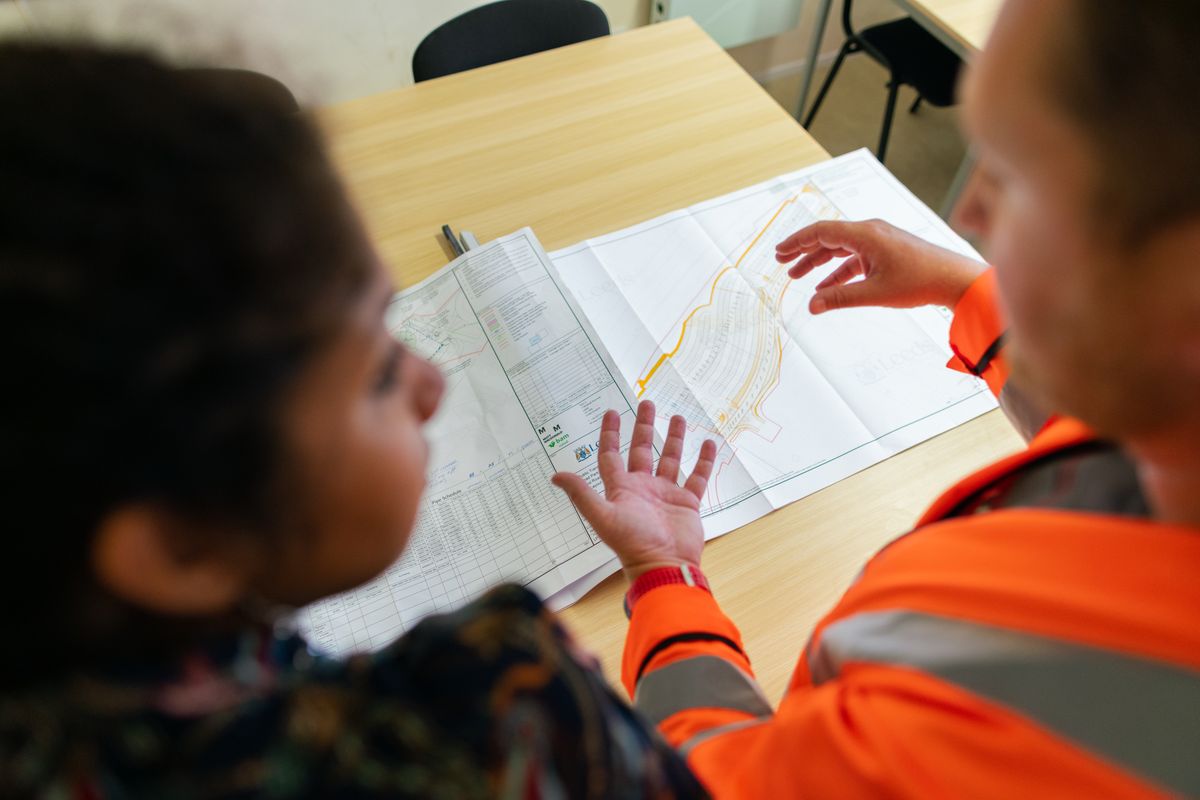 Engenheiros revisando projetos técnicos em mesa de trabalho